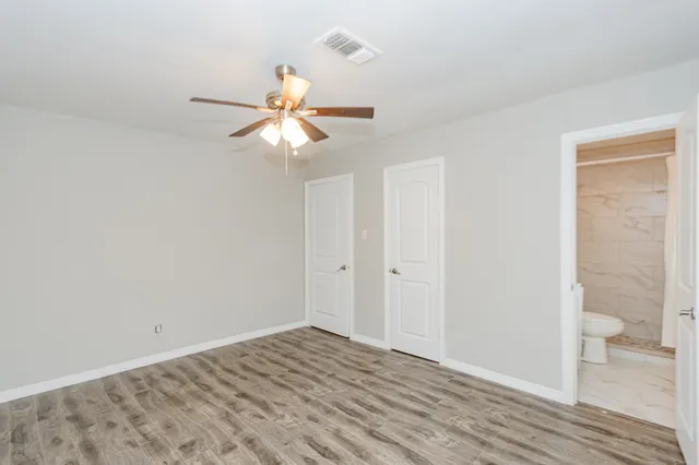 a view of a room with wooden floor and a ceiling fan
