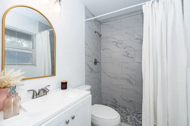 a bathroom with a sink a toilet and shower