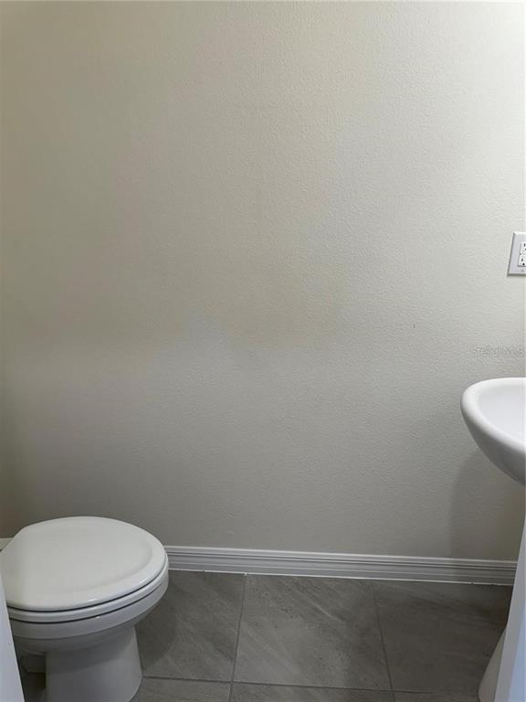 4561 Small Creek Road Kissimmee, FL 34744 - Photo 12 of 32 a bathroom with a toilet and a sink