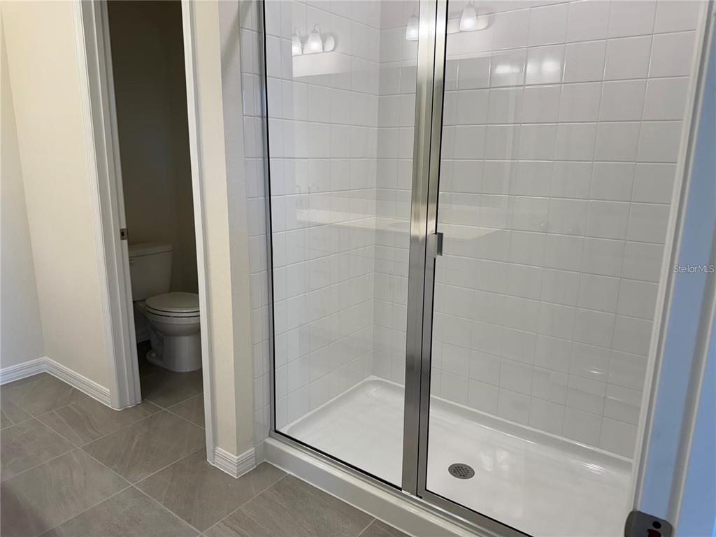 4561 Small Creek Road Kissimmee, FL 34744 - Photo 23 of 32 a bathroom with a glass shower door