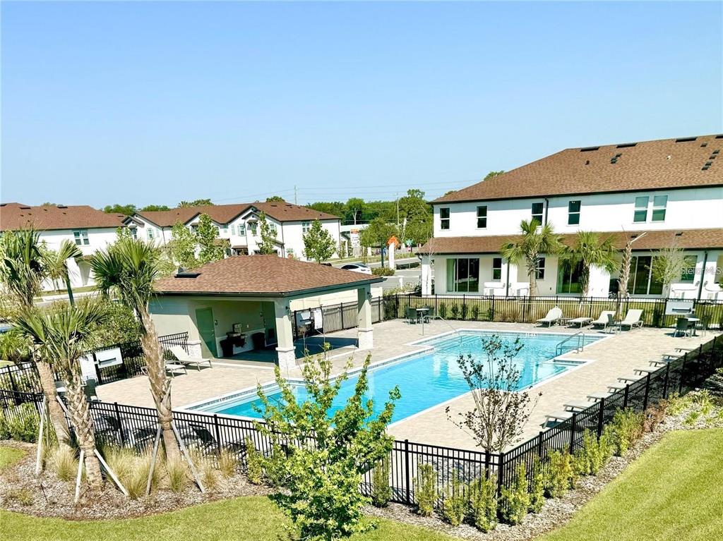 4561 Small Creek Road Kissimmee, FL 34744 - Photo 30 of 32 a view of a patio with couches table and chairs under an umbrella