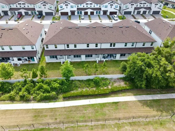 an aerial view of residential houses with yard and lake view