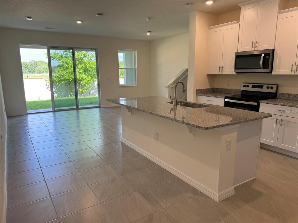 4561 Small Creek Road Kissimmee, FL 34744 - Photo 5 of 32 a kitchen with stainless steel appliances granite countertop a sink and a stove
