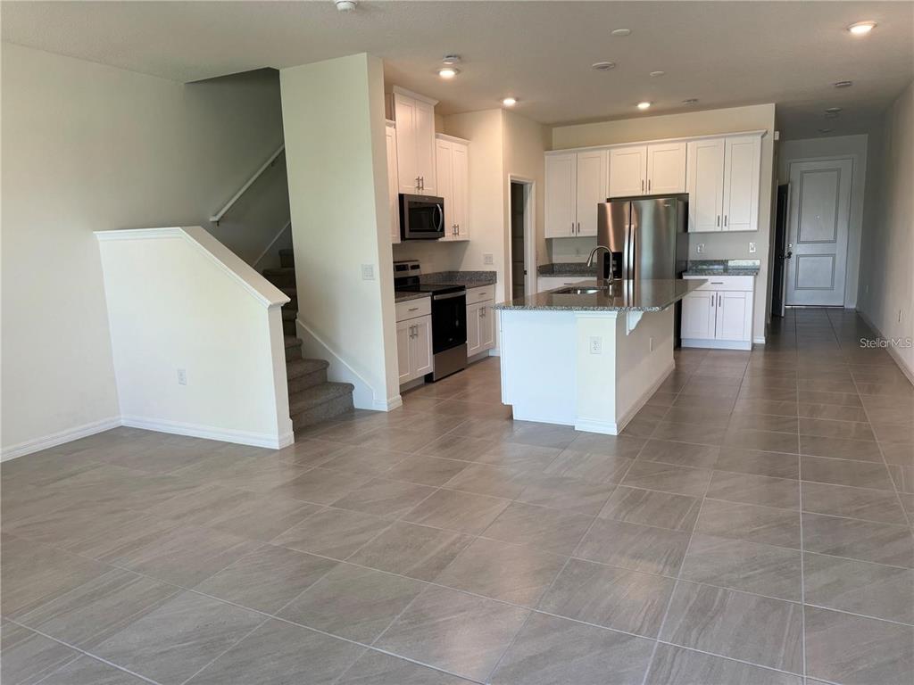 4561 Small Creek Road Kissimmee, FL 34744 - Photo 7 of 32 a view of a kitchen with refrigerator and chairs