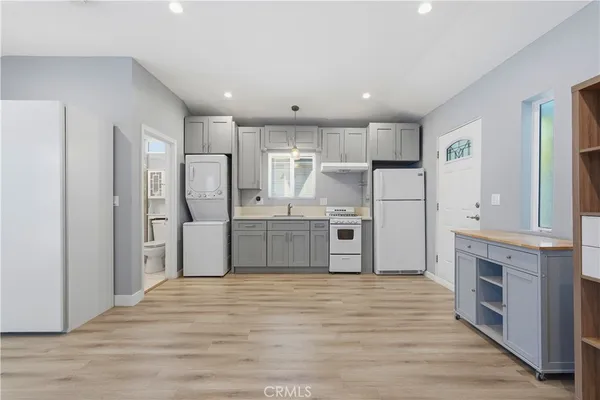 a kitchen with a refrigerator stove and white cabinets