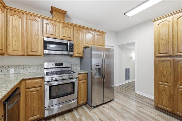 6309 32nd Street Groves, TX 77619 - Photo 11 of 34 a kitchen with stainless steel appliances granite countertop a refrigerator stove and microwave