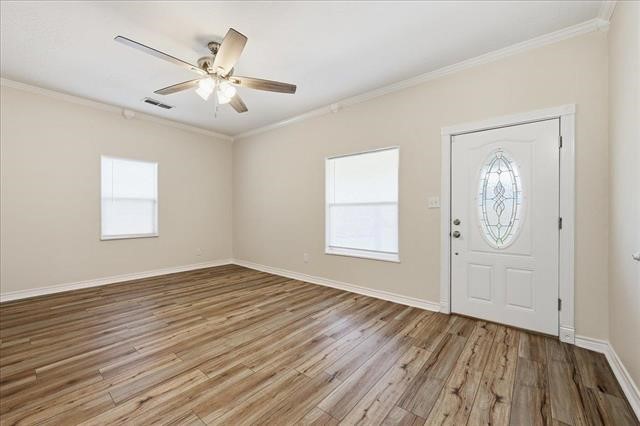 6309 32nd Street Groves, TX 77619 - Photo 5 of 34 a view of an empty room with wooden floor and a window