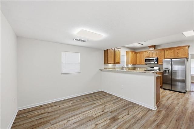6309 32nd Street Groves, TX 77619 - Photo 6 of 34 a kitchen with stainless steel appliances a refrigerator and cabinets