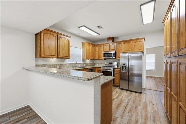 6309 32nd Street Groves, TX 77619 - Photo 7 of 34 a kitchen with granite countertop a refrigerator a sink a stove and island