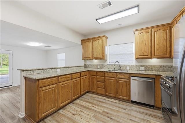 6309 32nd Street Groves, TX 77619 - Photo 8 of 34 a kitchen with granite countertop cabinets stainless steel appliances a sink and a window