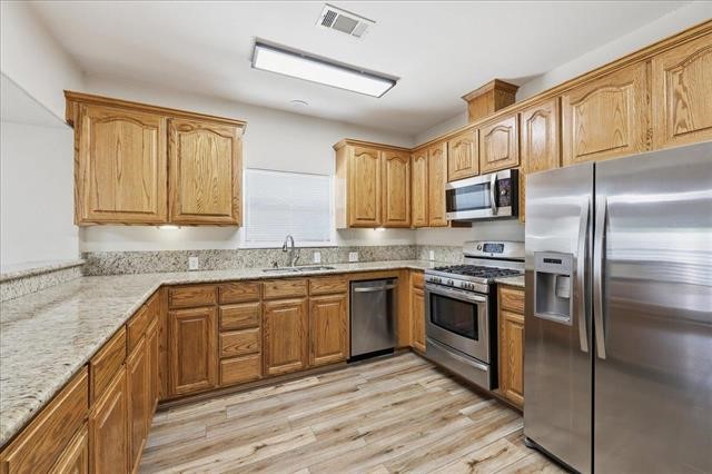 6309 32nd Street Groves, TX 77619 - Photo 9 of 34 a kitchen with stainless steel appliances granite countertop a refrigerator a stove top oven a sink and dishwasher
