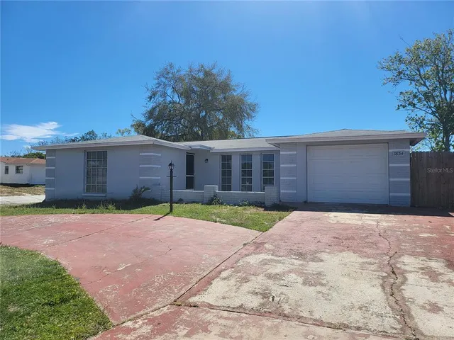 a front view of a house with a yard and a garage