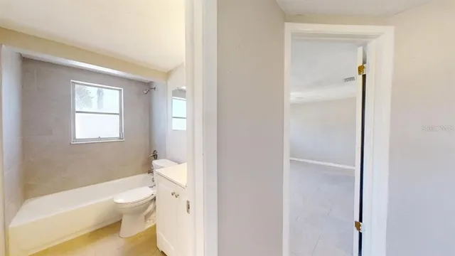 a white toilet sitting next to a bathroom sink and vanity