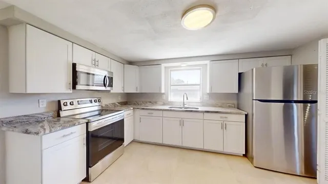 a kitchen with stainless steel appliances granite countertop a refrigerator sink and stove