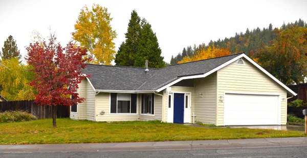 a front view of a house with a garden and yard