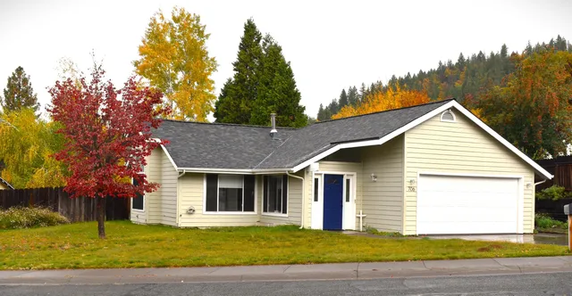 a front view of a house with a garden and yard
