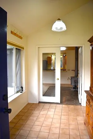 a view of a hallway with wooden floor and a living room
