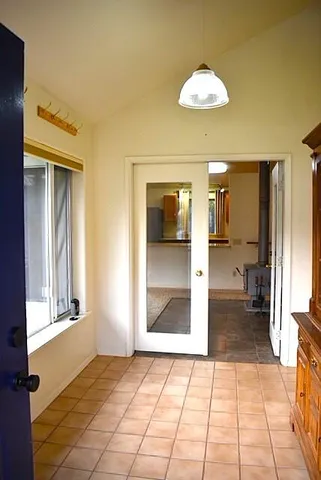 a view of a hallway with wooden floor and a living room