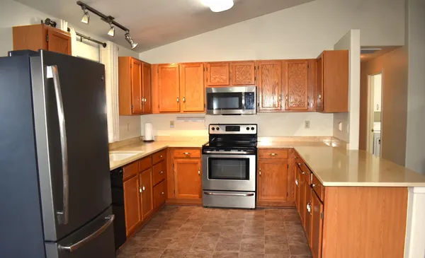 a kitchen with stainless steel appliances a refrigerator sink and microwave