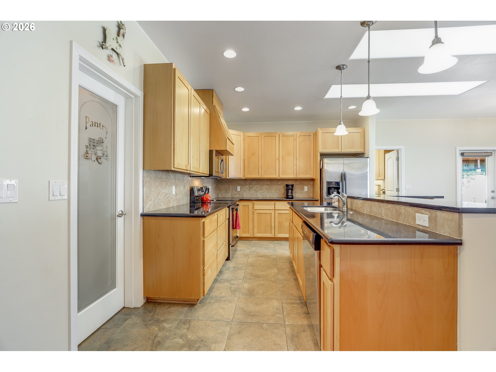 1901 Golden Way The Dalles, OR 97058 - Photo 11 of 48 a kitchen with kitchen island granite countertop a stove a sink a refrigerator and white cabinets with wooden floor