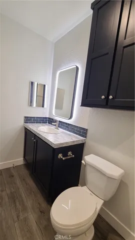 a view of a kitchen with wooden floor and cabinets