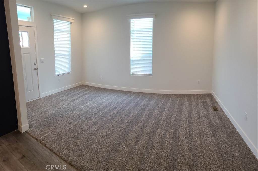 2139 East 4th Street, Unit 79 Ontario, CA 91764 - Photo 3 of 18 an empty room with wooden floor and windows