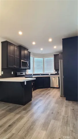 a large kitchen with stainless steel appliances kitchen island granite countertop a large counter top and a stove top oven