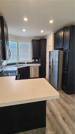 a kitchen with stainless steel appliances a refrigerator sink and wooden cabinets