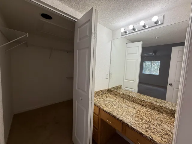 a bathroom with a granite countertop sink and a mirror