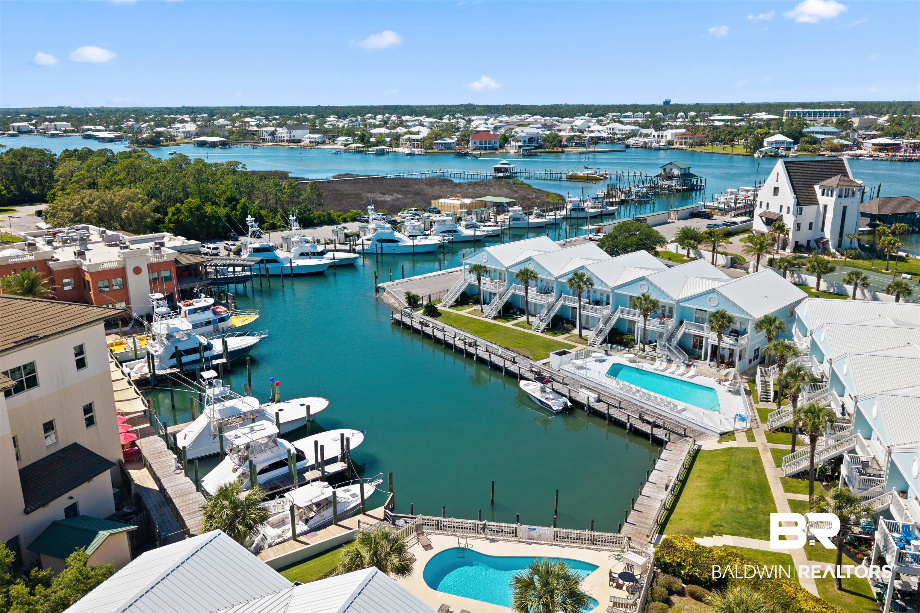 3543 Bayou Road, Unit 5 Orange Beach, AL 36561 - Photo 30 of 33 Waterfront property featuring a private marina with multiple boat slips, a rectangular swimming pool, and dedicated green spaces