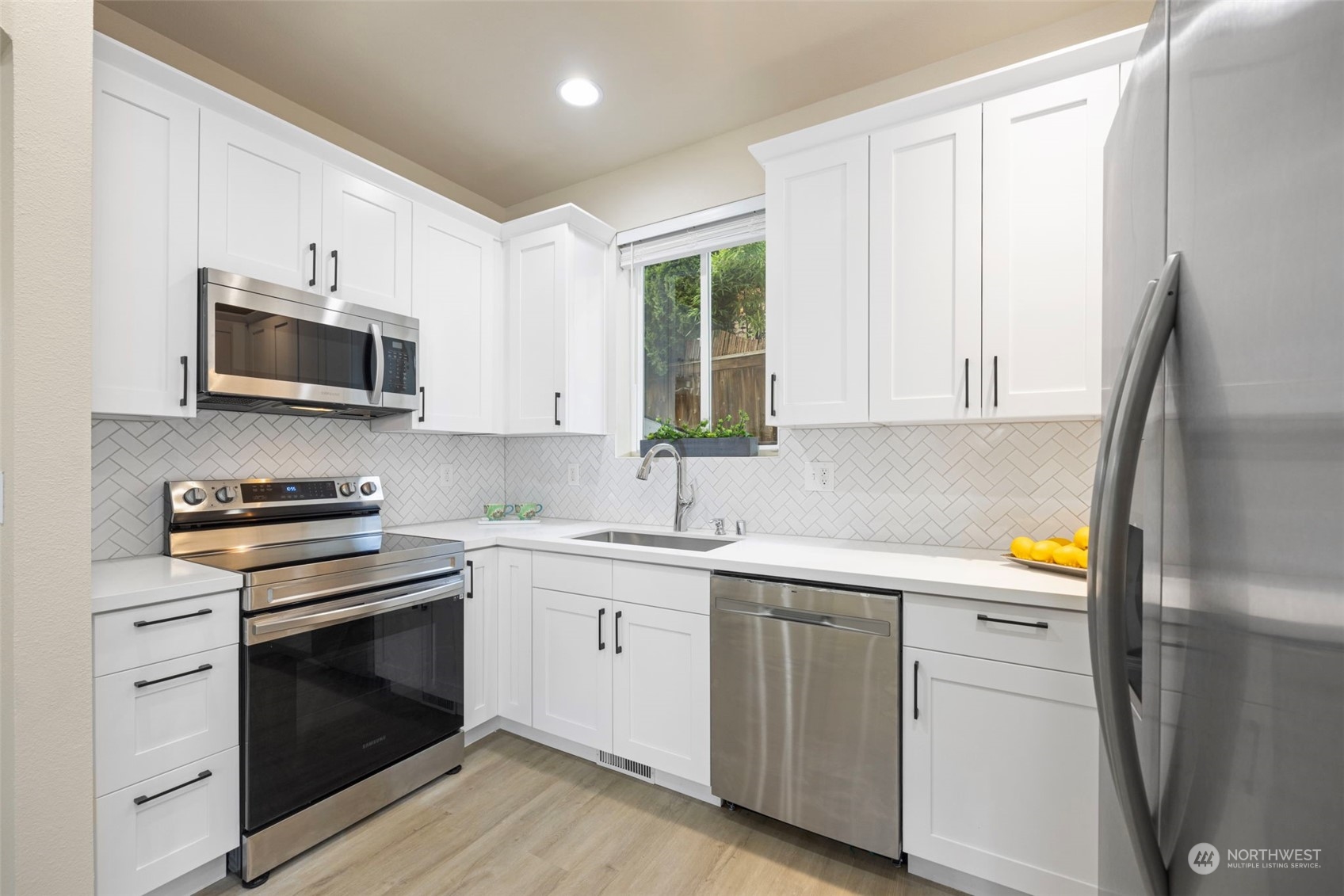 320 Graham Avenue Northeast Renton, WA 98059 - Photo 10 of 26 a kitchen with white cabinets stainless steel appliances and sink