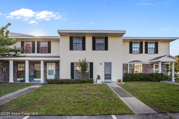 front view of a brick house with a yard