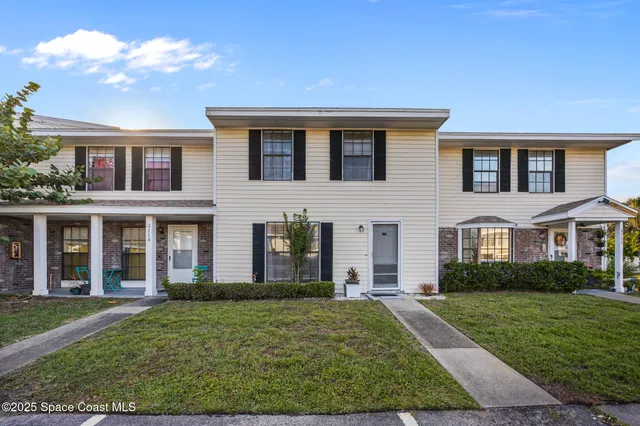 front view of a brick house with a yard
