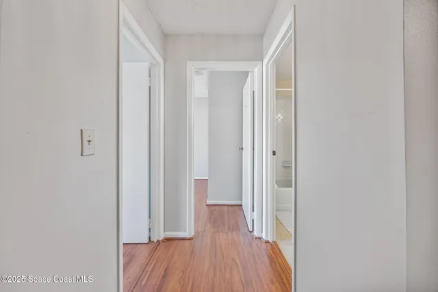 a view of a hallway with wooden floor