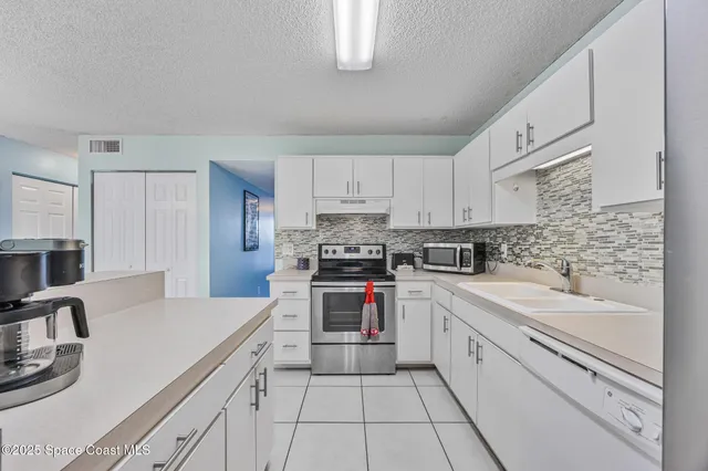 a kitchen with cabinets appliances a sink and a counter top space