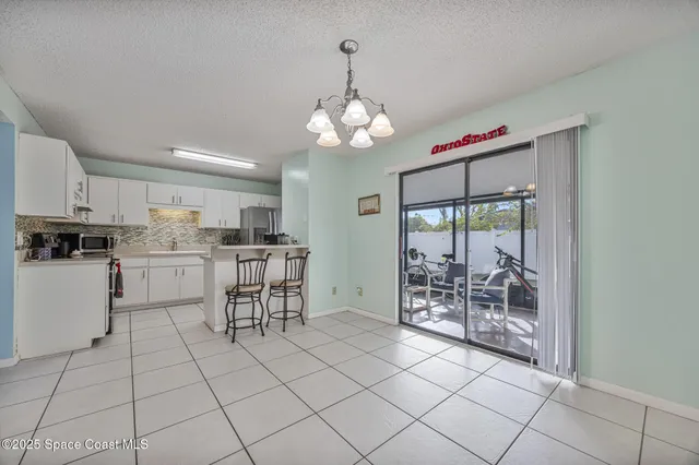 a kitchen with cabinets and chairs