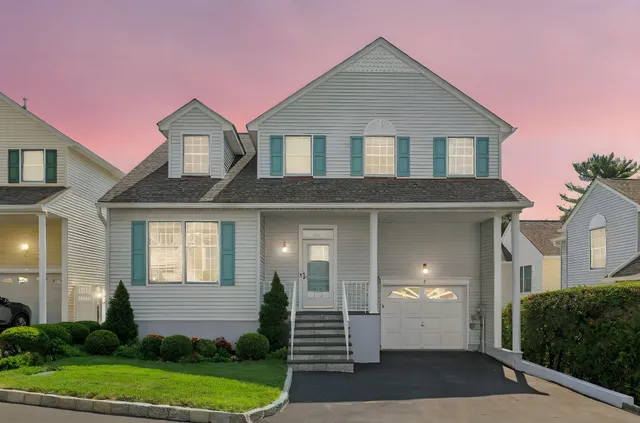 a front view of a house with a yard and potted plants