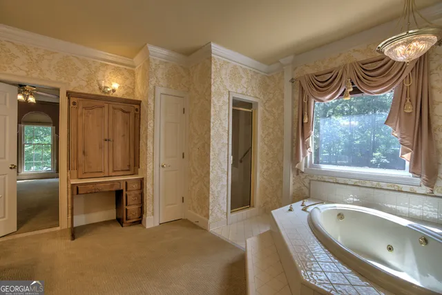 a view of a livingroom with a chandelier fan and a window