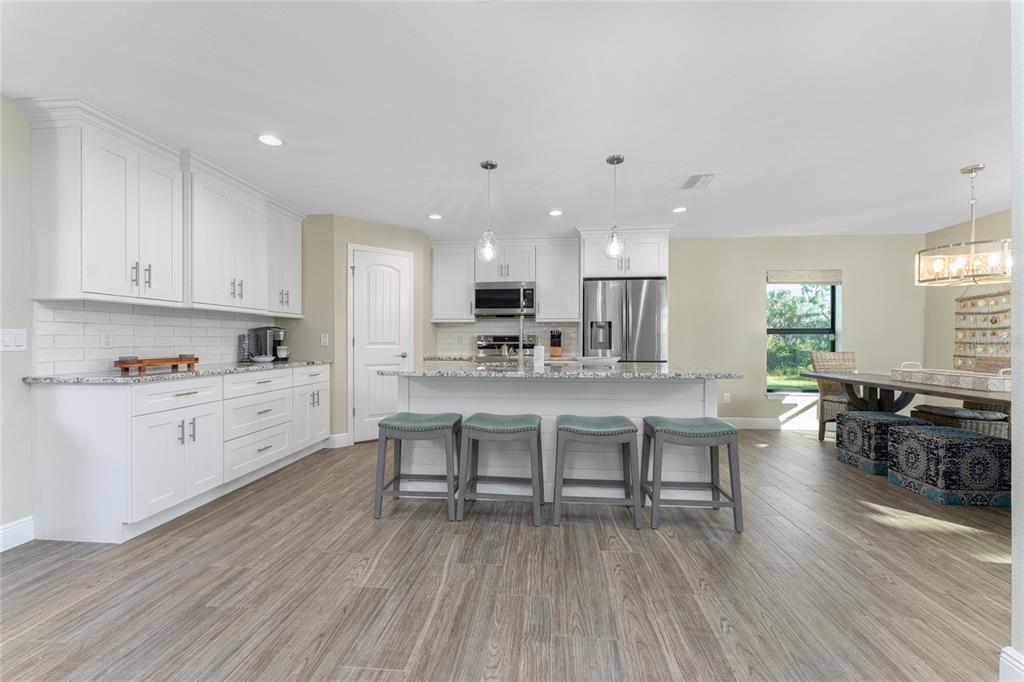 184 Spring Drive Rotonda West, FL 33947 - Photo 12 of 54 a kitchen with a dining table chairs and wooden floor