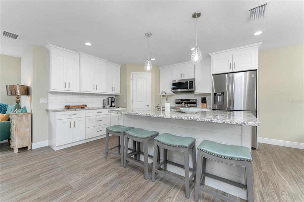 184 Spring Drive Rotonda West, FL 33947 - Photo 13 of 54 a kitchen with white cabinets stainless steel appliances and a dining table