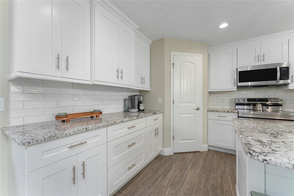 184 Spring Drive Rotonda West, FL 33947 - Photo 14 of 54 a kitchen with granite countertop white cabinets and stainless steel appliances