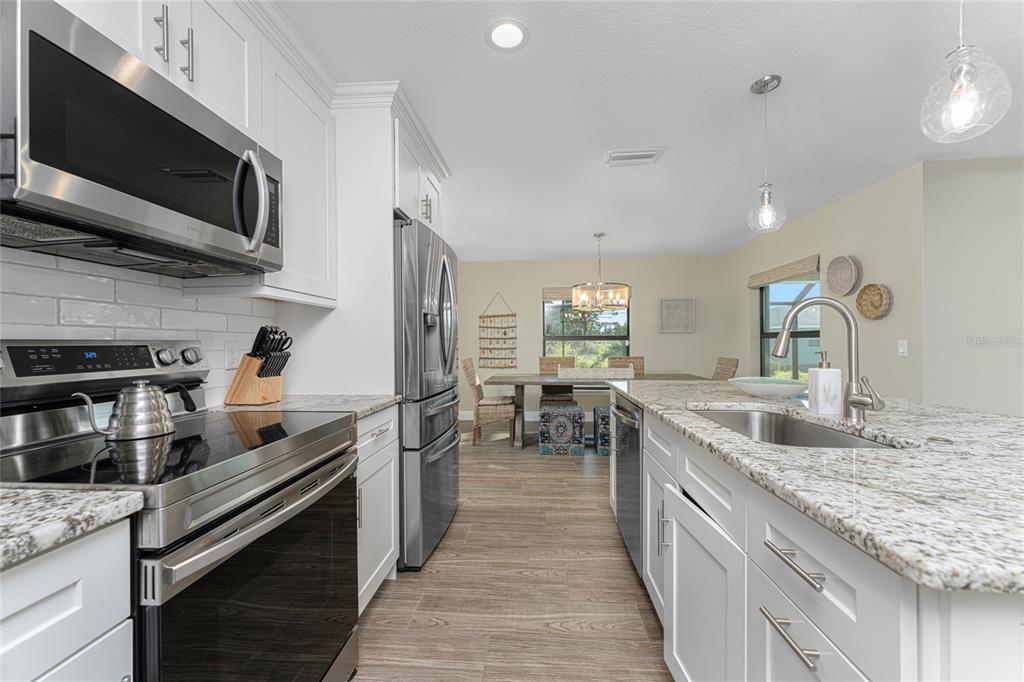 184 Spring Drive Rotonda West, FL 33947 - Photo 16 of 54 a kitchen with stainless steel appliances granite countertop a sink and a stove