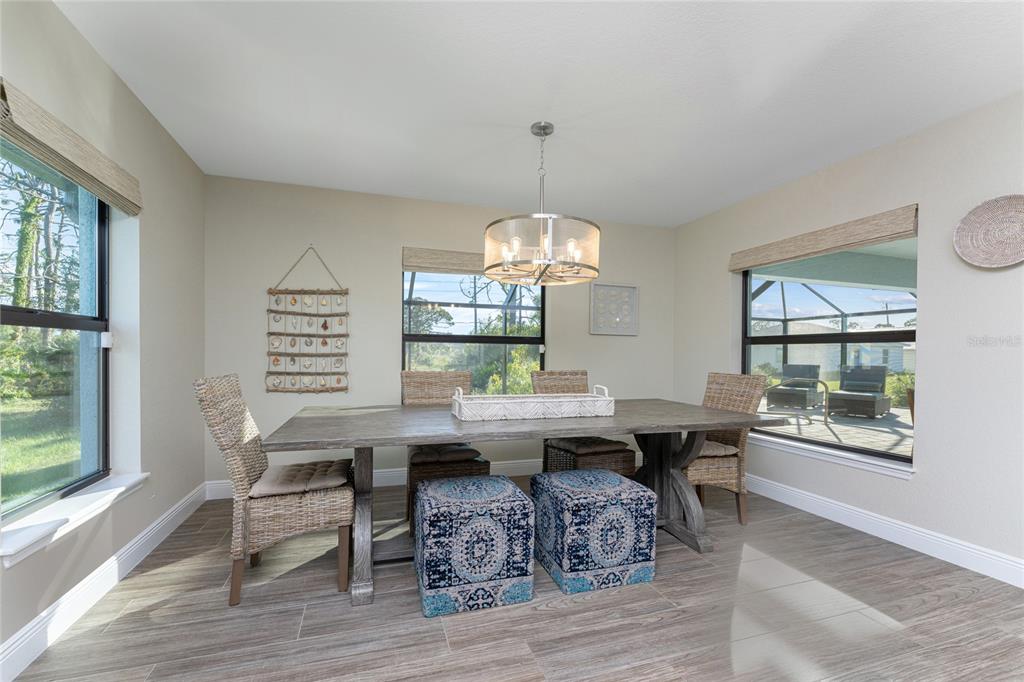184 Spring Drive Rotonda West, FL 33947 - Photo 19 of 54 a view of a dining room with furniture a chandelier and wooden floor