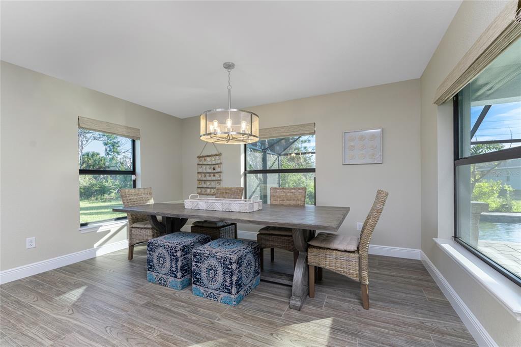 184 Spring Drive Rotonda West, FL 33947 - Photo 20 of 54 a view of a dining room with furniture a chandelier and wooden floor