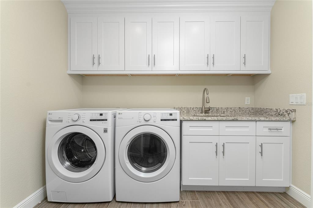 184 Spring Drive Rotonda West, FL 33947 - Photo 22 of 54 a utility room with granite countertop white cabinets and stainless steel appliances