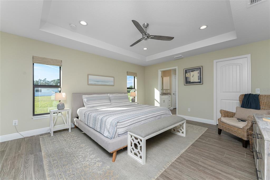 184 Spring Drive Rotonda West, FL 33947 - Photo 32 of 54 a spacious bedroom with a bed and wooden floor