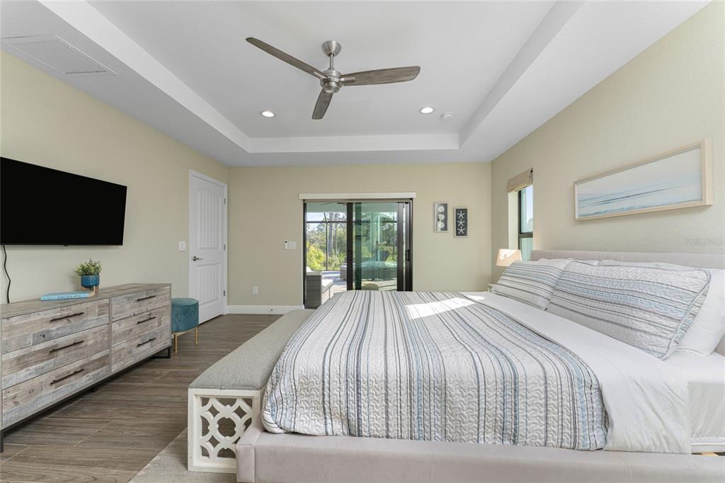 184 Spring Drive Rotonda West, FL 33947 - Photo 34 of 54 a bedroom with a large bed a flat tv screen and large dresser