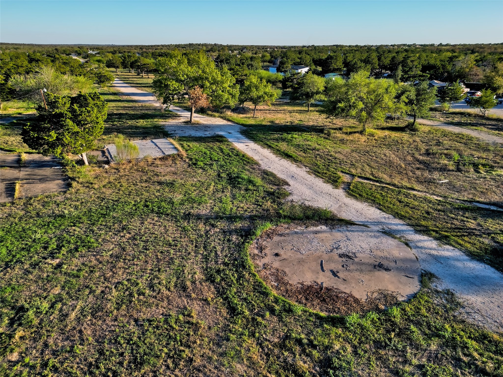 11622 Doyle Overton Road Austin, TX 78719 - Photo 11 of 15 Mature trees dot this sprawling acreage featuring unpaved access paths and open green terrain.