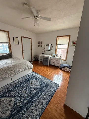 a bedroom with a bed and wooden floor