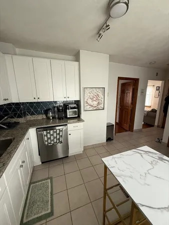 a kitchen with stainless steel appliances granite countertop a stove a sink and a white cabinets